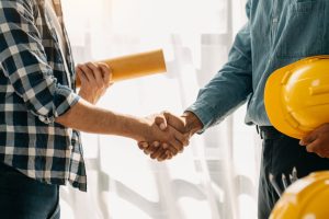 Müteahhitlik Construction team shake hands greeting start new project plan behind yellow helmet on desk in modern office center to consults about their building project.